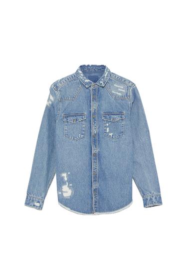 Front view of a blue denim shirt with front pockets and distressed details.