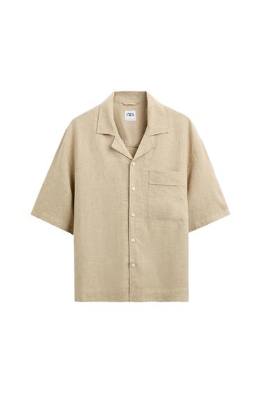 Beige short-sleeved shirt with a lapel collar, front button fastening and chest pocket against a white background. ZARA label on the collar.