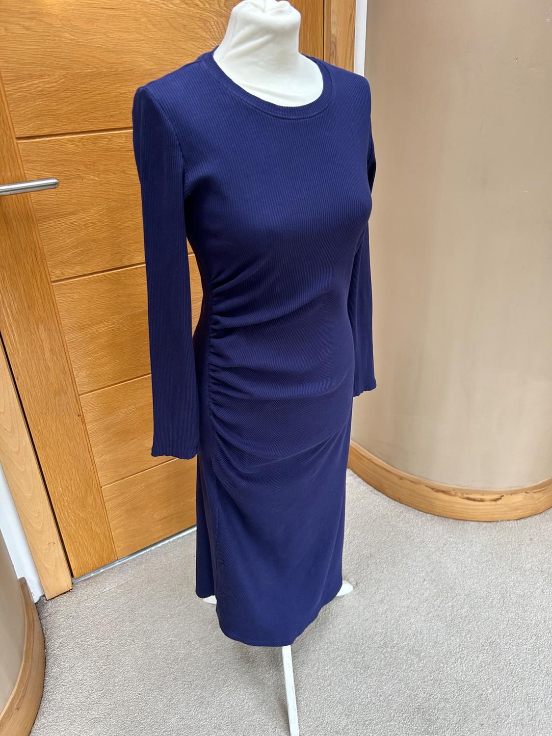 Side view of a dark blue dress with side ruching and long sleeves.