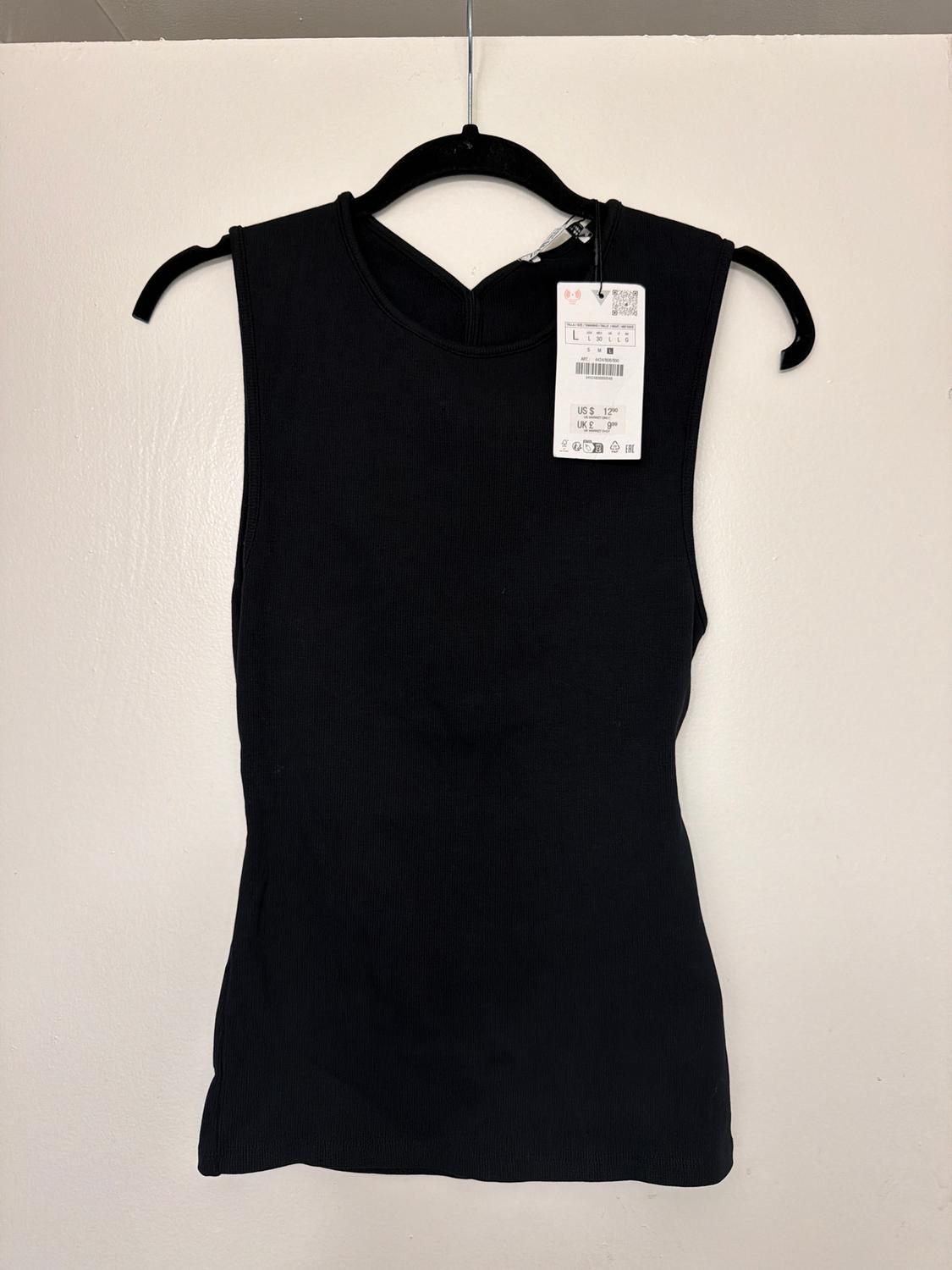 Black sleeveless t-shirt hanging on a black hanger against a white background. Visible tag with price and size details.