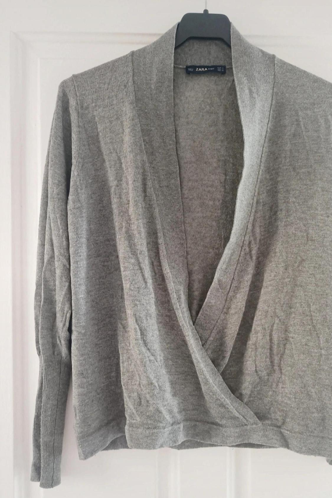 Front view of a grey cardigan with open neck and long sleeves.