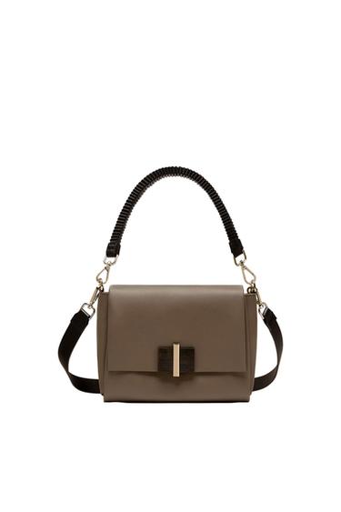Brown handbag with a textured black handle and adjustable strap. Front closure with a gold metallic detail on a white background.