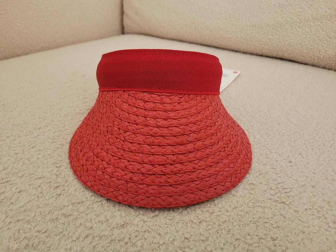 Red woven visor on a beige sofa. Blurred background, relaxed and cosy atmosphere.