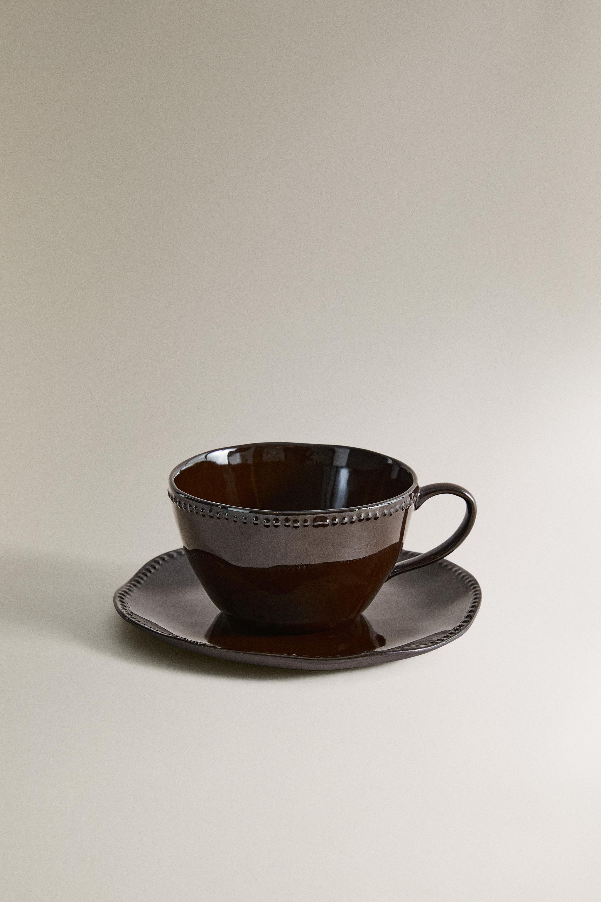 STONEWARE COFFEE CUP AND SAUCER WITH RAISED DESIGN