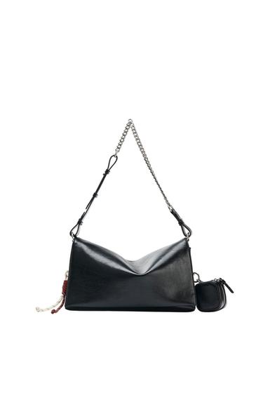 Black shoulder bag with a chain strap and a carry handle. Slouchy design featuring a small hanging coin purse and decorative cords on the side.