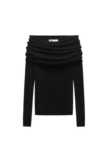 Long-sleeved black sweater with a draped neckline. Visible label with the text "ZARA". White background.