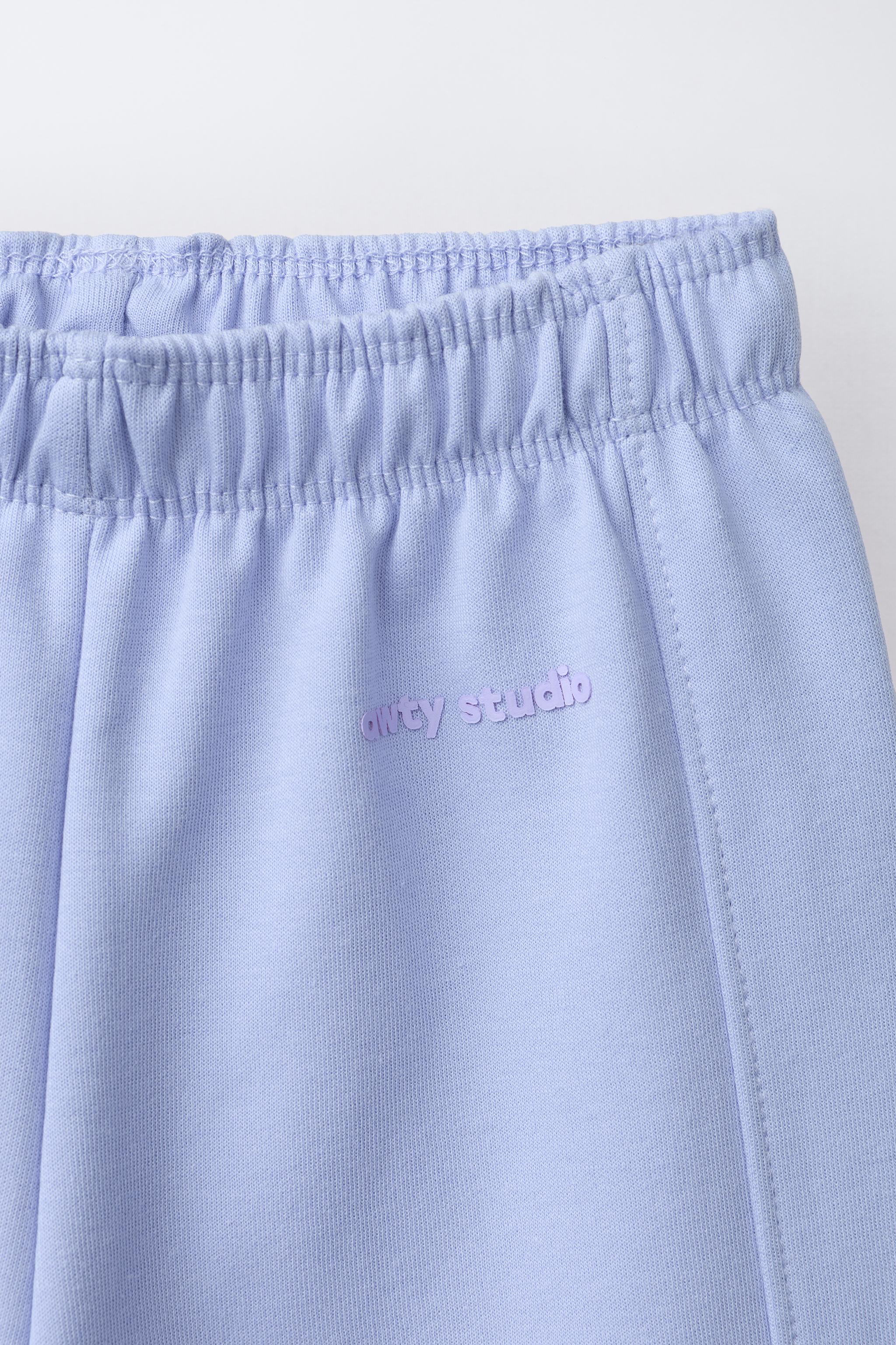 WIDE LEG INTERLOCK RAISED TEXT PANTS