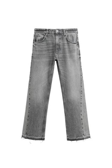 Front view of gray jeans with front pockets and frayed hem.