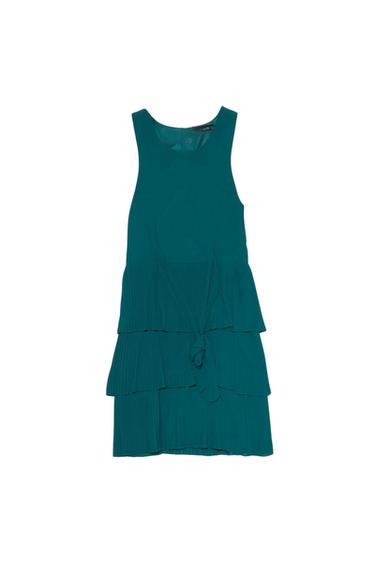 Front view of green dress with ruffles and a bow at the waist.