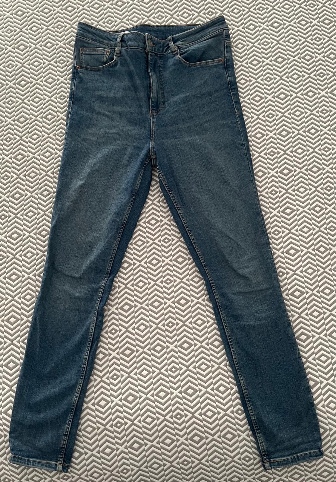 Dark blue jeans on a surface with a white and grey geometric pattern.