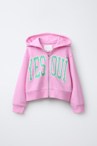 Vorderansicht eines rosa Hoodies mit Kapuze und Reißverschluss. Reliefartiger Text "YES OUI" auf der Brust.