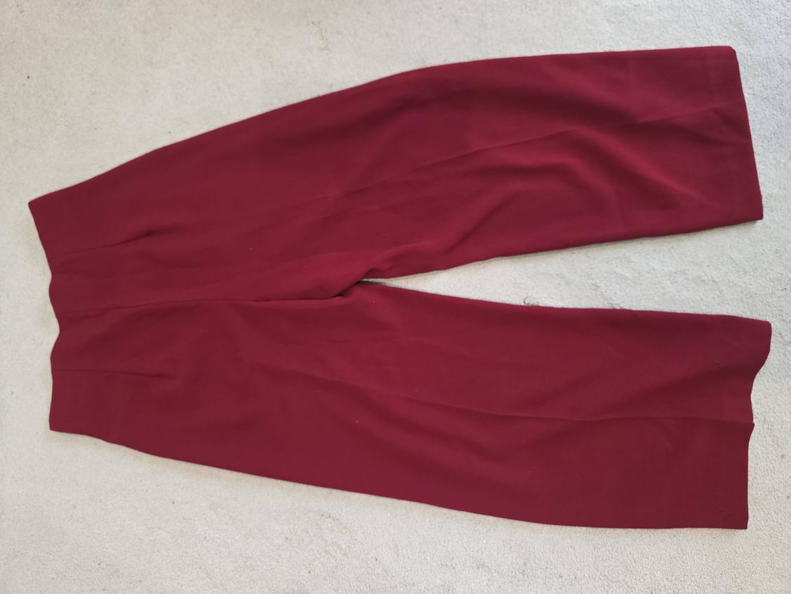 Dark red wide-leg trousers on a light surface.