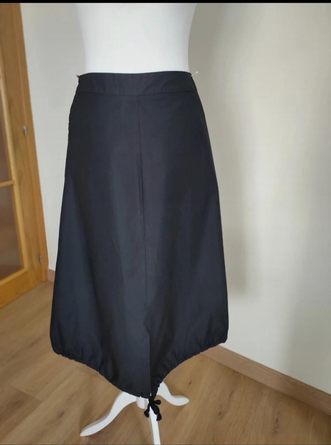 Front view of black skirt with drawstring at hem.
