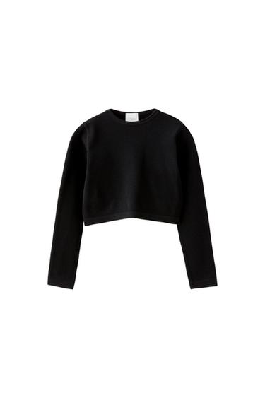 Front view of a black long-sleeved, cropped sweater.