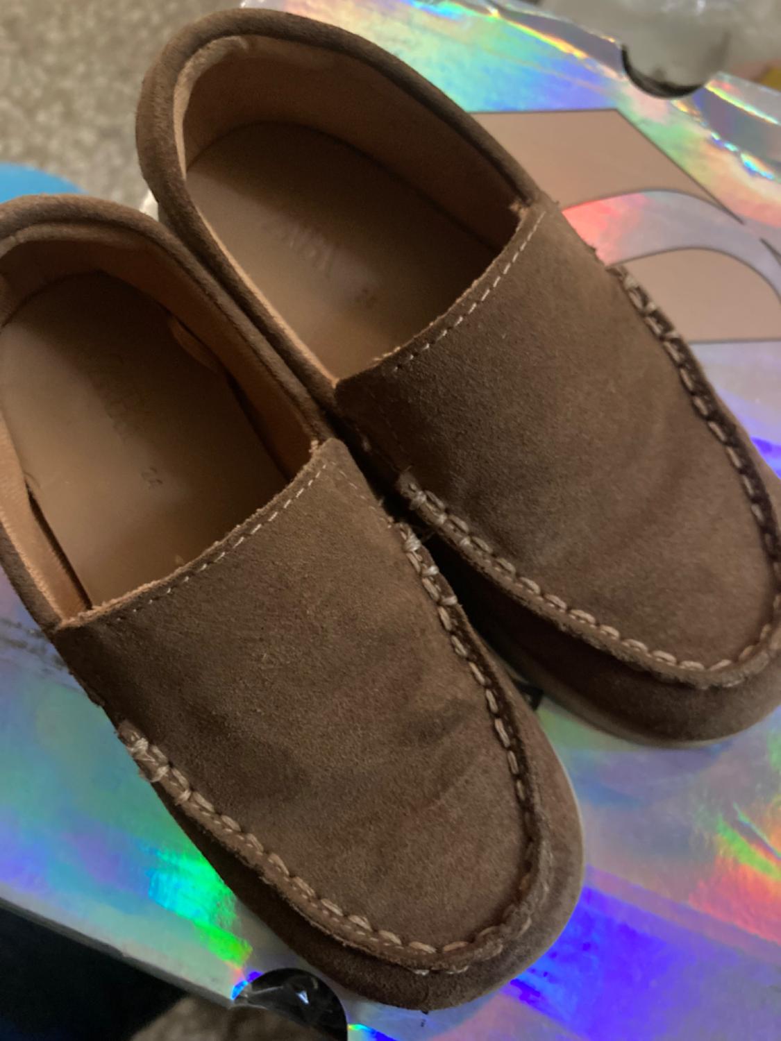 Close-up of brown loafers with visible stitching.