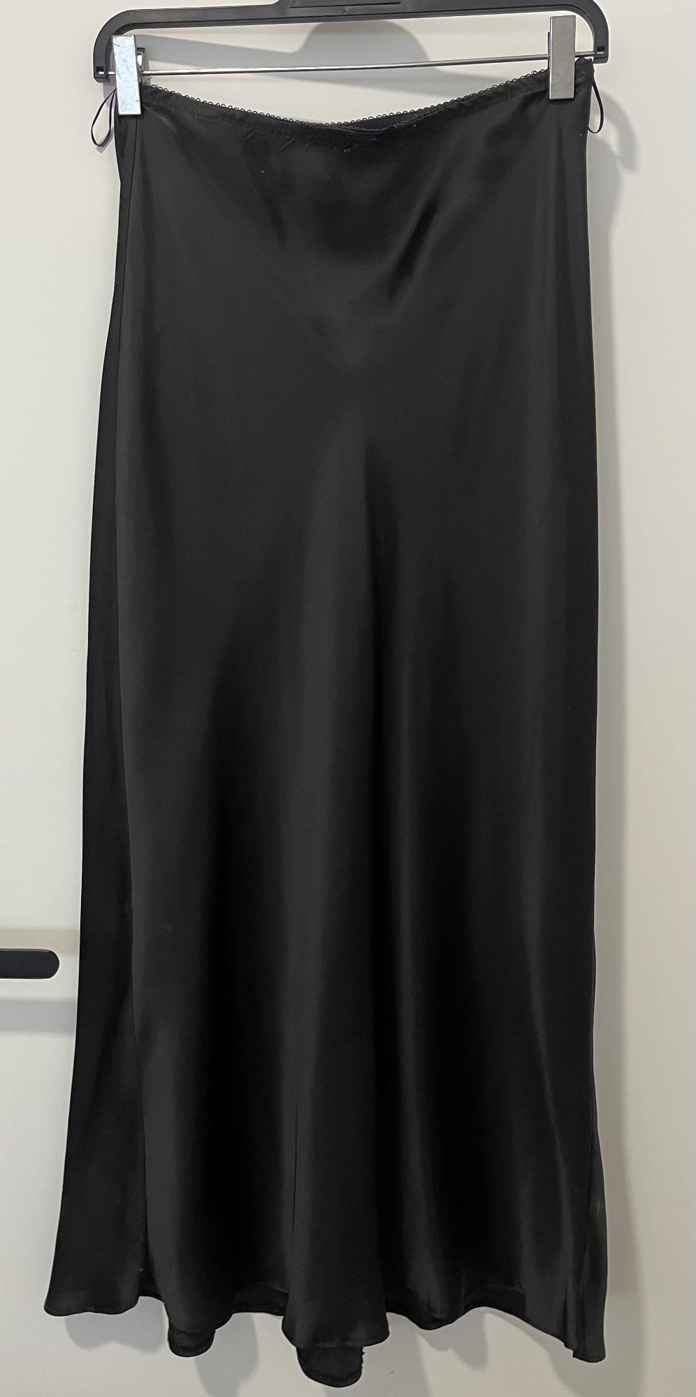 Long black satin skirt hanging on a hanger against a white background.