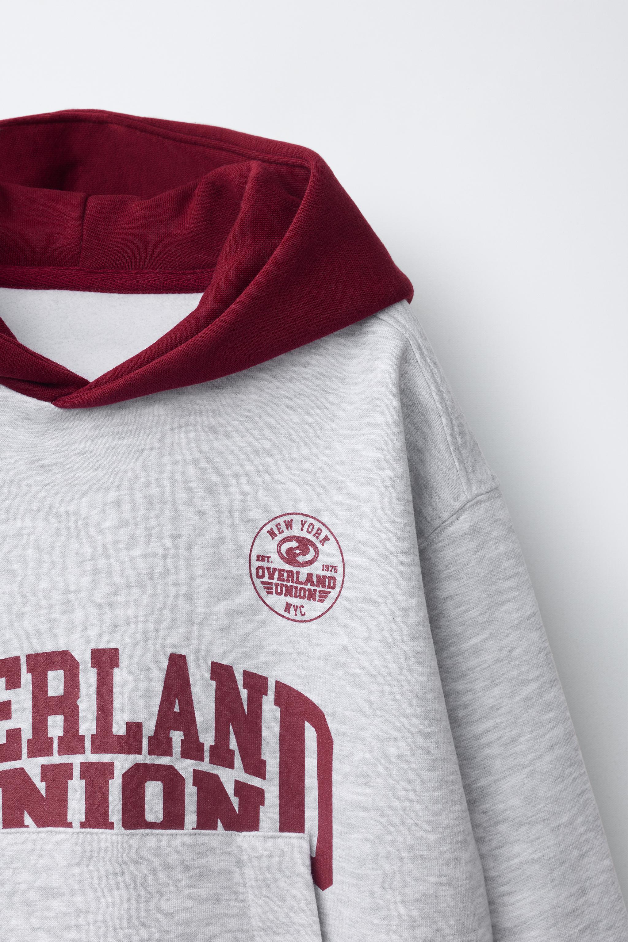 SWEAT À CAPUCHE ET INSCRIPTION