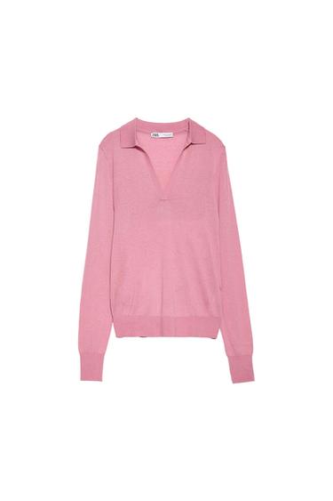 Pink, long-sleeved jumper with a V-neck and fitted cuffs. Visible label on the inside of the neck. White background.