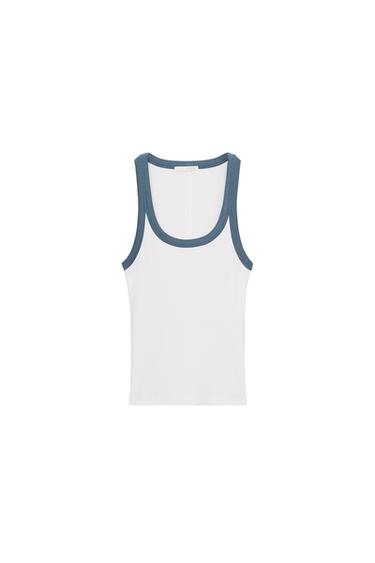 Front view of a white top with blue trim on the round neckline and armholes. Straight hem.
