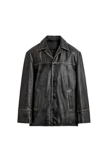 Black leather jacket with a distressed effect, collar, button-up front fastening and side pockets against a white background.