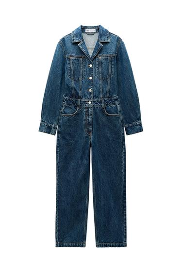 Front view of a blue denim jumpsuit with buttons and front pockets.