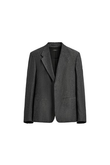 Front view of a grey marl blazer with notch lapels, flap pockets at the hip, and a front button fastening.