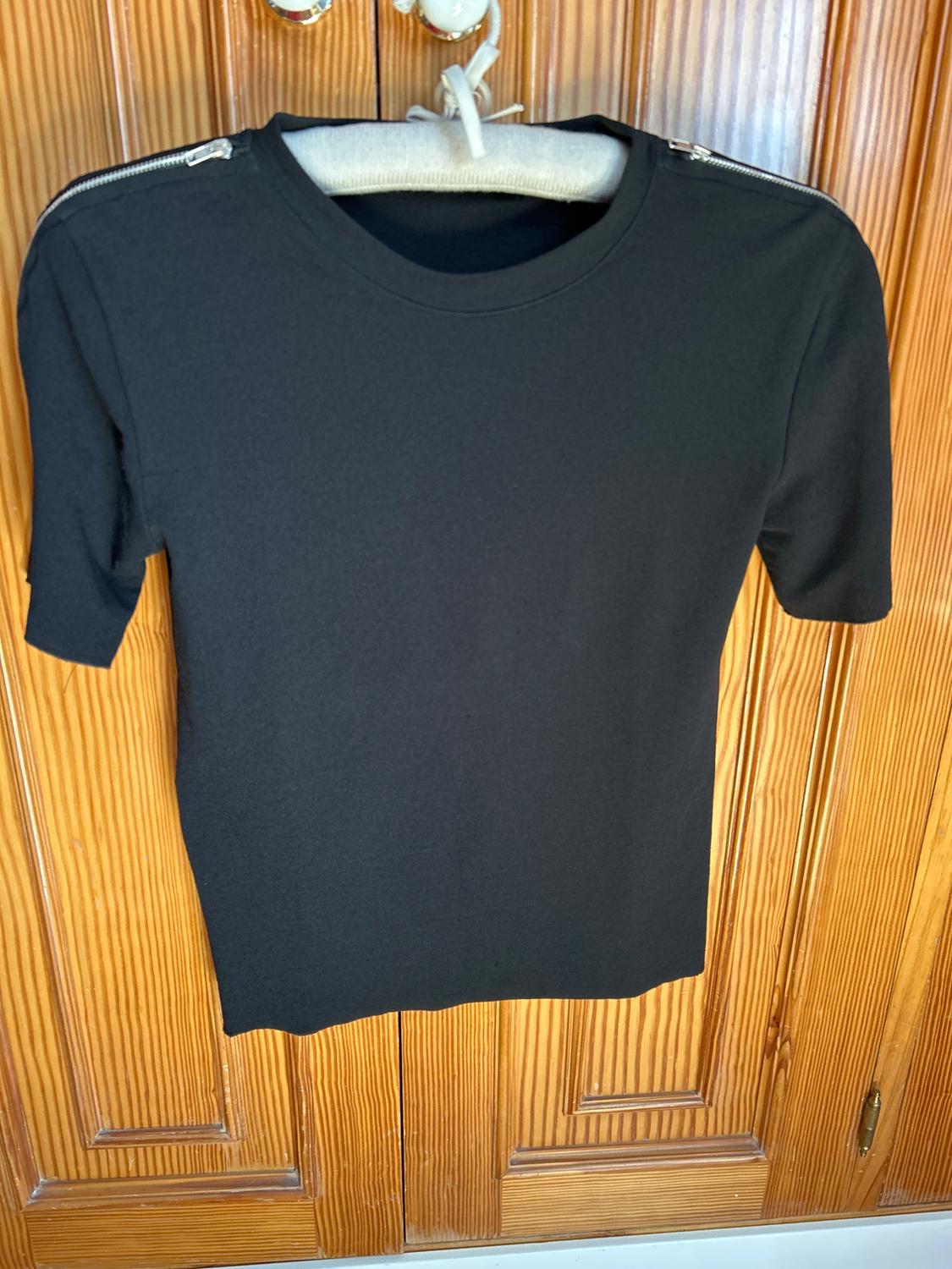 Front view of a black t-shirt with zips on the shoulders.