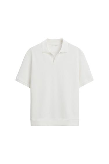 White polo shirt with short sleeves, a ribbed texture, and an open collar, on a white background.