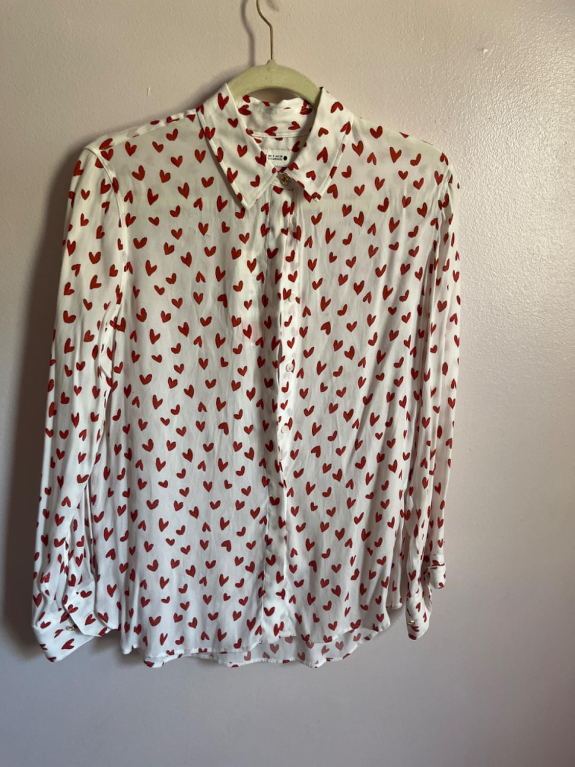 Front view of a white shirt with a red heart print and a classic collar.