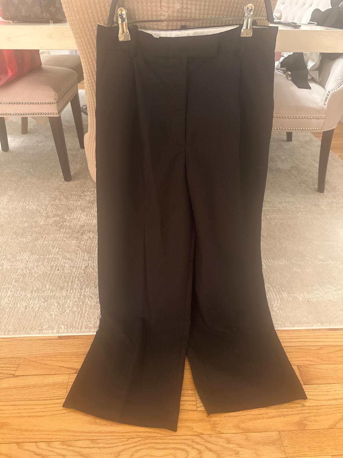 Front view of black trousers with pleats and a wide hem.