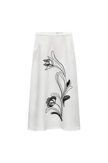 White skirt with black floral design on the side.