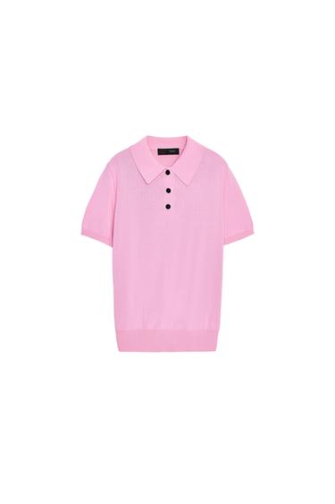 Front view of a pink polo top with a classic collar, short sleeves, and black buttons on the front.