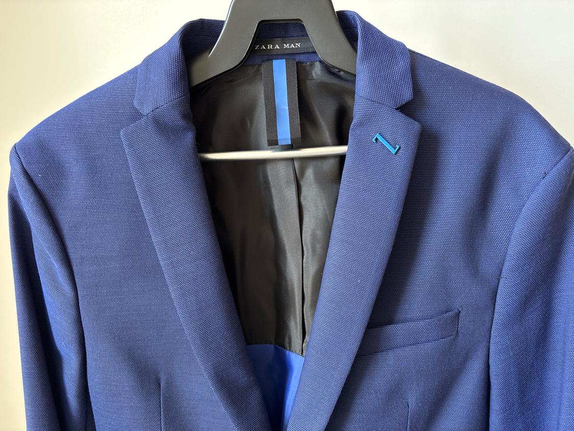 Close-up of a blue jacket with a lapel and left chest pocket