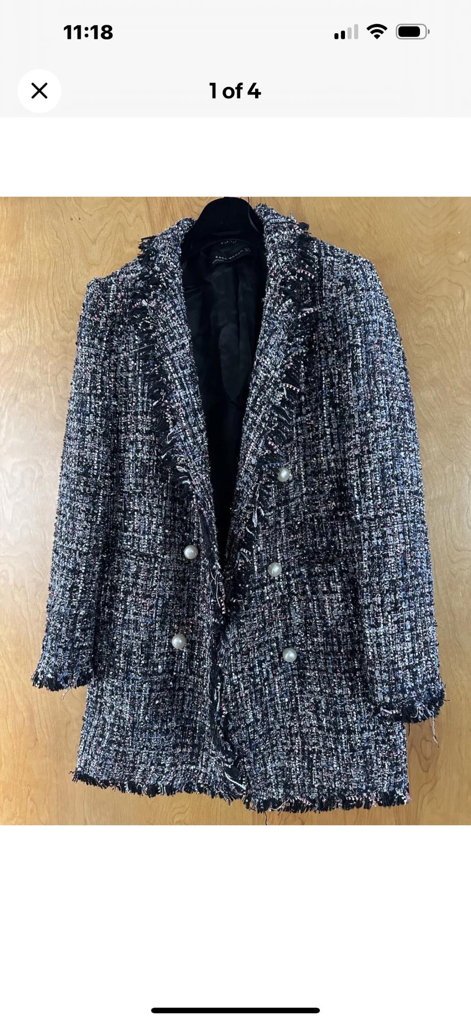 Front view of a textured coat with pearly buttons and frayed lapels.