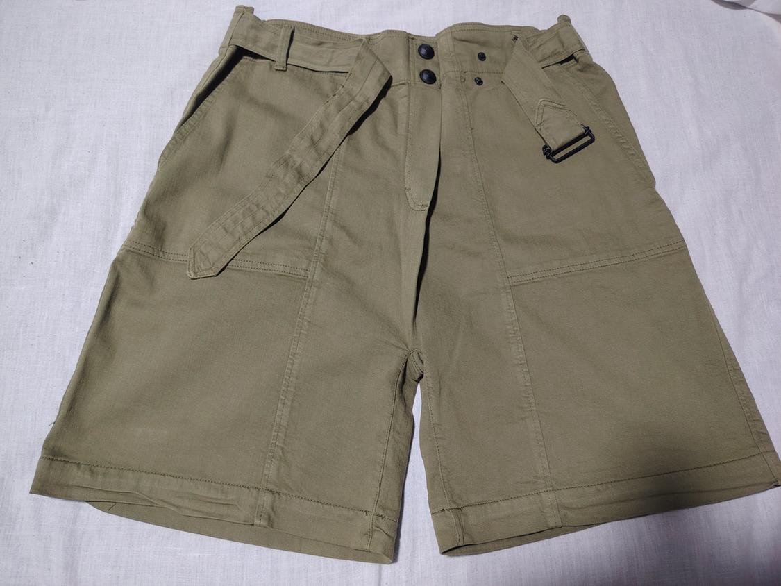Khaki shorts with belt and black buckle on a white background. Casual design with pockets and front buttons.