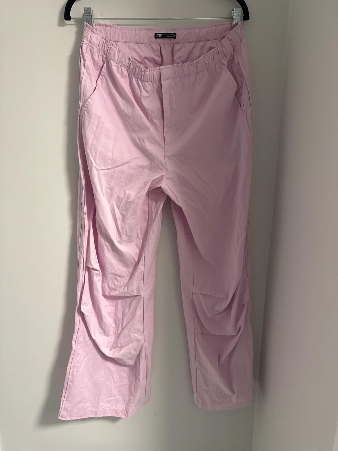 Front view of pink trousers with elasticated waistband and side pockets