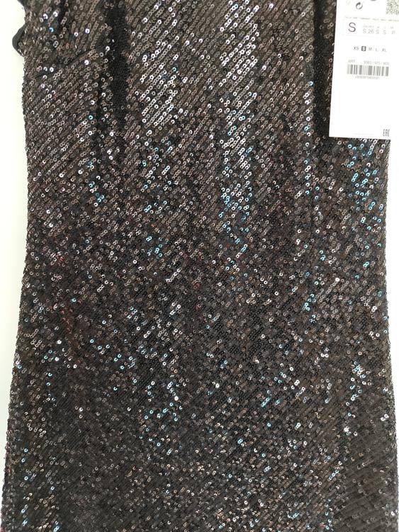 Black and silver sequinned dress with visible tag on the right. White background.