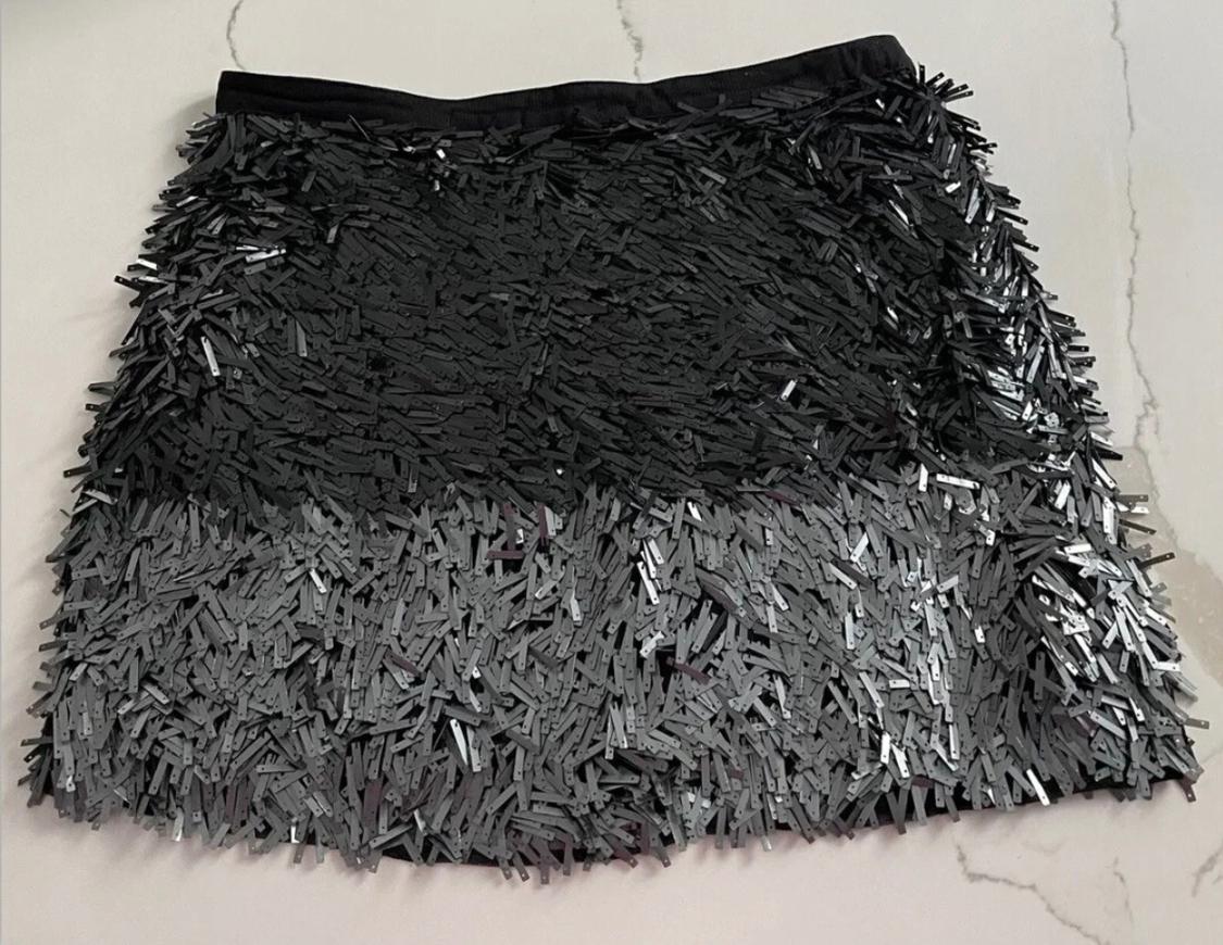 Black and grey short skirt with shiny fringe texture on a light background.