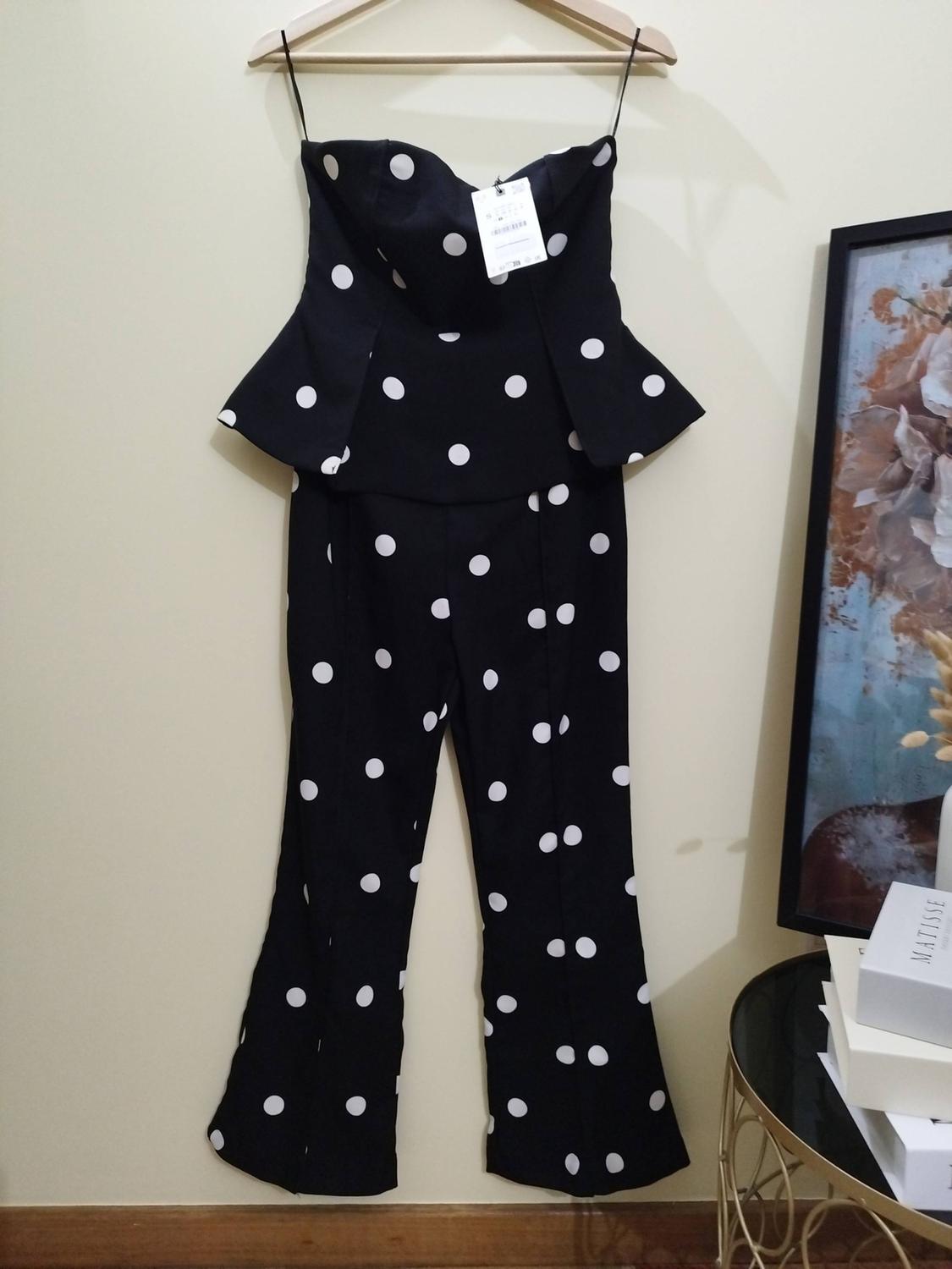 Black top and trousers polka-dot set on a hanger. Next to it, a picture frame and a white box with the text MATISSE.