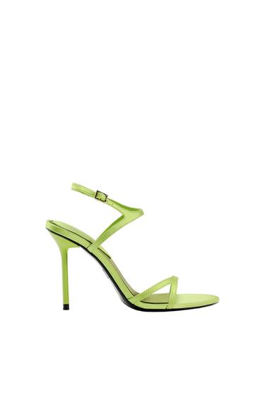 Lime green high-heeled sandal with thin straps and buckle fastening, on a white background.
