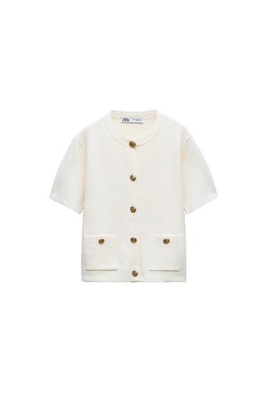 Front view of a white short-sleeved jacket with gold buttons and front pockets