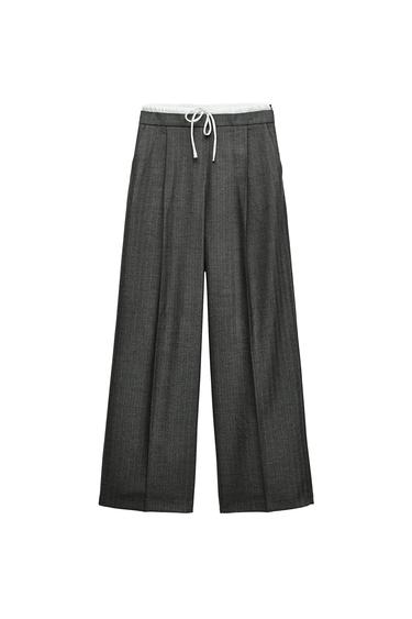 Front view of gray pants with adjustable waist and pleats.