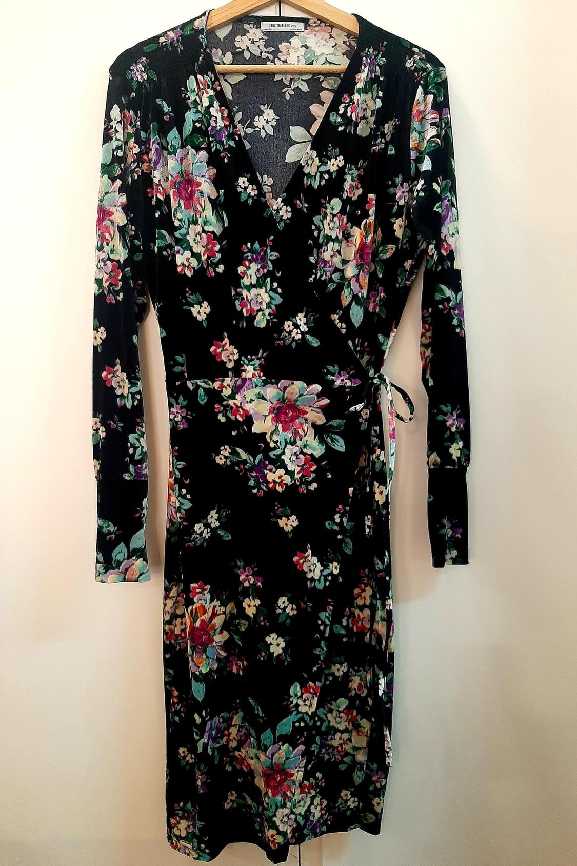 Front view of black dress with floral print and bow at the waist.