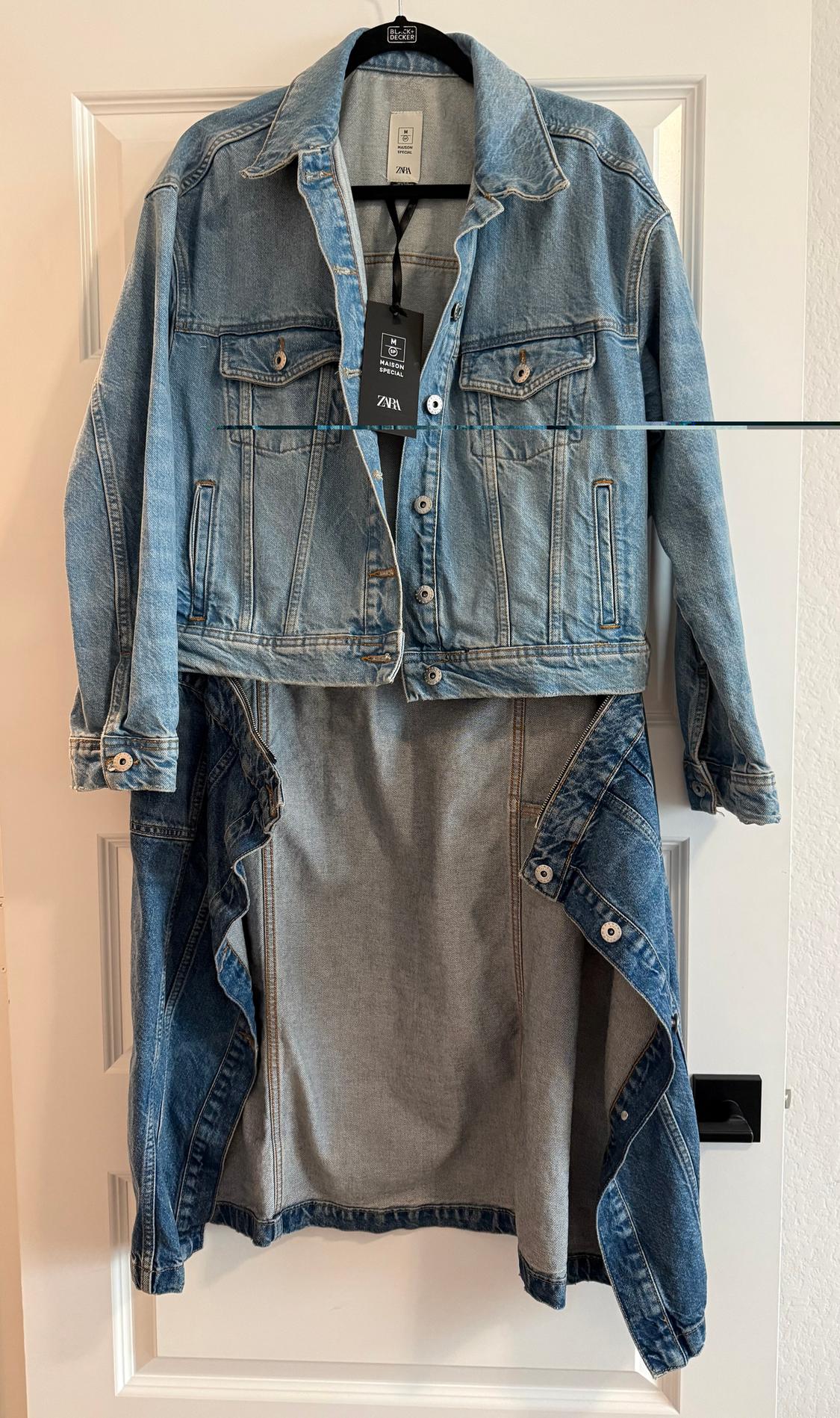 Light blue denim jacket hanging on a white door, with a black Zara tag visible on the collar.
