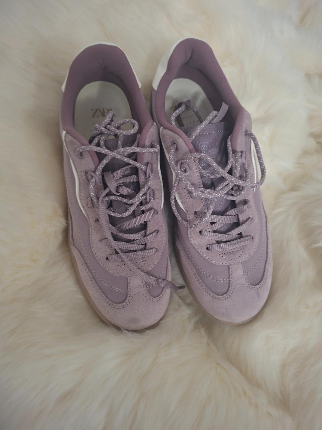 Αθλητικά sneakers από σουέτ και δέρμα σε μωβ τόνο πάνω σε βάση από λευκό συνθετικό γούνινο ύφασμα. Λογότυπο ZARA ορατό στο εσωτερικό του παπουτσιού.