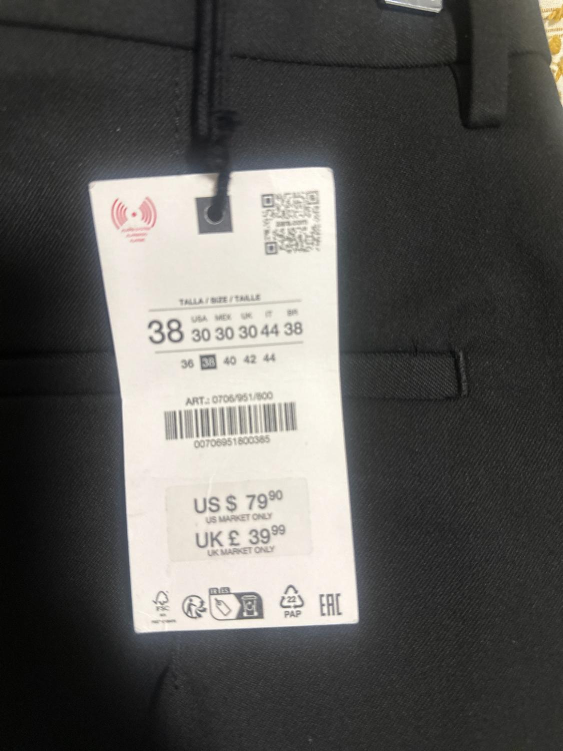 Black pants with tag. Text: TALLA / SIZE / TAILLE 38, ART.: 0706/951/800, US $ 79.90 US MARKET ONLY, UK £ 39.99 UK MARKET ONLY.