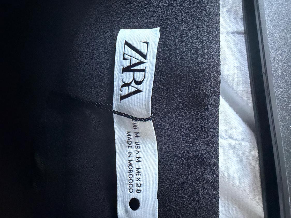 Clothing label with the text "ZARA, EUR M, USA M, MEX 28, MADE IN MOROCCO" on black and white fabric.