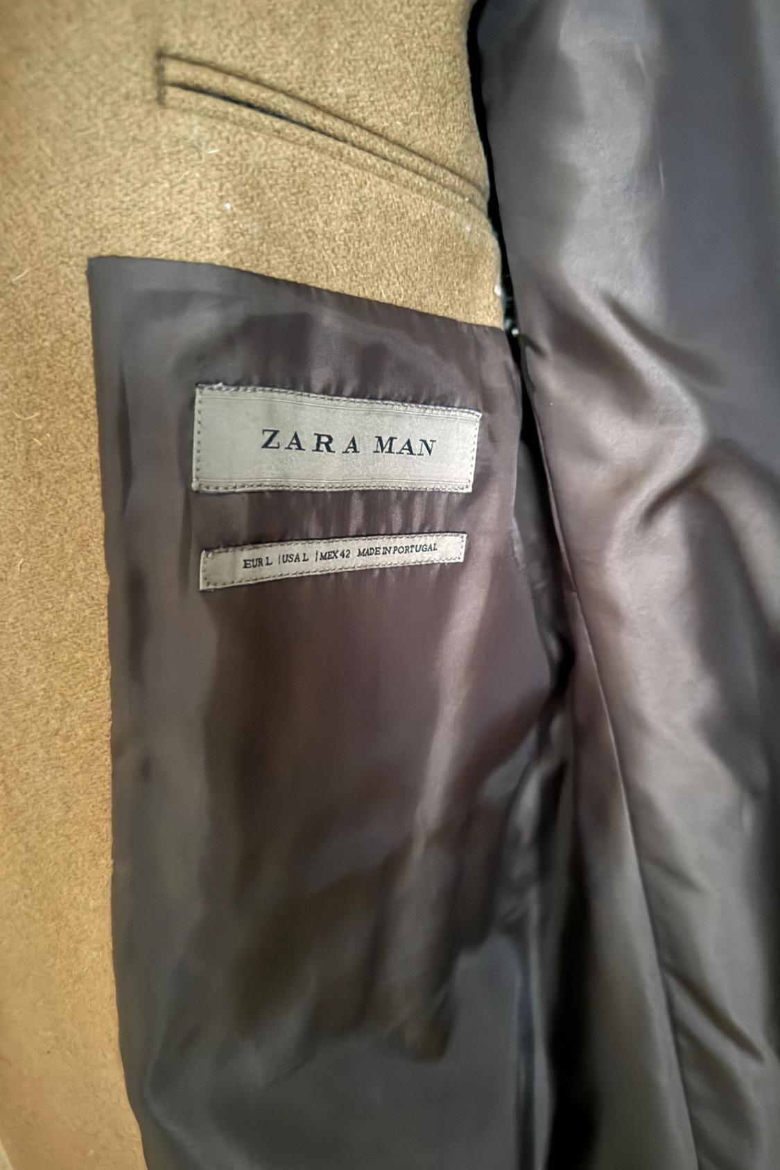 Detail of the inner lining of a brown coat with a 'Zara Man' label and size 'EUR L / USA L / MEX 42'.