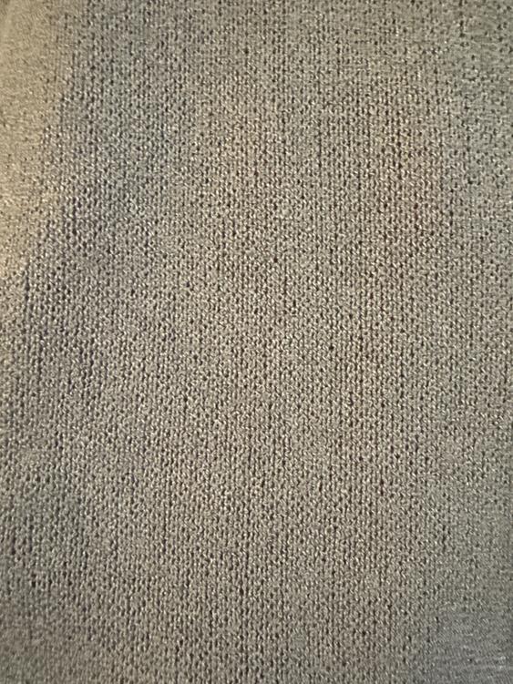Close-up of a gray knit fabric with visible texture, showing a uniform and soft pattern.