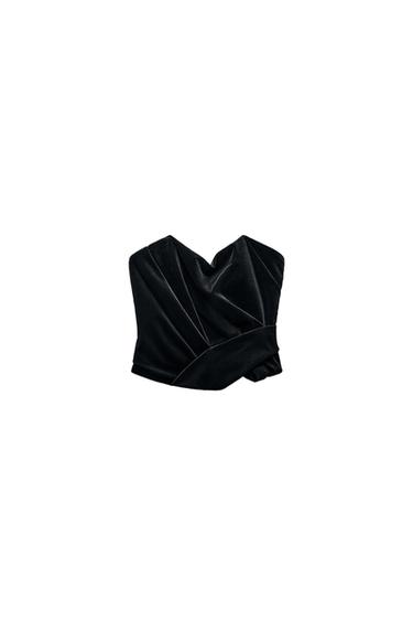 Front view of a black top with ruching and a sweetheart neckline.